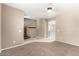 Spacious living room showcasing neutral walls, carpet, tile flooring, and a glimpse of the staircase and open archway at 8795 W Windsor Dr, Peoria, AZ 85381
