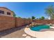 Beautiful backyard pool with rock waterfall feature and ample space for lounging, secluded by a brick wall at 8795 W Windsor Dr, Peoria, AZ 85381