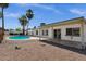 The white home features a covered patio and a swimming pool set in a desert landscape with white block fence at 9330 E Kalil Dr, Scottsdale, AZ 85260