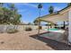 View of backyard with covered patio, desert landscaping, block fence, and swimming pool in the background at 9330 E Kalil Dr, Scottsdale, AZ 85260