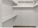 Walk-in closet featuring wooden look floors and built-in shelves and hanging space, offering ample storage at 9330 E Kalil Dr, Scottsdale, AZ 85260