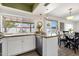The well-lit kitchen showcases white cabinets, stainless steel appliances, and a breakfast bar overlooking the pool at 9330 E Kalil Dr, Scottsdale, AZ 85260