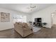 Bright living room features a modern ceiling fan, wood-look tile flooring, and a large window for natural light at 9330 E Kalil Dr, Scottsdale, AZ 85260