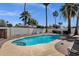 The crystal-clear pool is surrounded by desert landscaping, palm trees, and a white block fence at 9330 E Kalil Dr, Scottsdale, AZ 85260