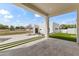 Expansive covered patio with travertine tile, integrated turf, and a view of the fenced yard, perfect for outdoor living at 9611 E Clinton St, Scottsdale, AZ 85260