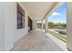 Long covered back patio with tile flooring overlooking the pool and landscaped backyard at 9611 E Clinton St, Scottsdale, AZ 85260