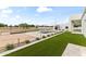 Spacious backyard featuring a pool, lush lawn, and a new modern home build at 9611 E Clinton St, Scottsdale, AZ 85260