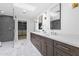 Modern bathroom featuring double vanity, marble floors, walk-in shower, and closet providing a luxurious retreat at 9611 E Clinton St, Scottsdale, AZ 85260