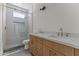 Modern bathroom featuring a glass shower, wooden cabinets, and a double sink vanity at 9611 E Clinton St, Scottsdale, AZ 85260