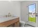 Modern bathroom featuring sleek gold hardware and a bright window with backyard views at 9611 E Clinton St, Scottsdale, AZ 85260