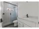 Modern bathroom featuring a glass-enclosed shower with stylish tile, a white vanity, and sleek black fixtures at 9611 E Clinton St, Scottsdale, AZ 85260