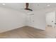 An open concept bedroom featuring a wooden ceiling fan, light hardwood floors, and white walls at 9611 E Clinton St, Scottsdale, AZ 85260