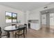 Dining area with hardwood floors, contemporary lighting, and a built-in wet bar adjacent to a large window at 9611 E Clinton St, Scottsdale, AZ 85260