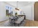 Dining room with table set for six under modern light fixture next to large window at 9611 E Clinton St, Scottsdale, AZ 85260