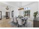 Dining room with table set for six under modern light fixture next to large window at 9611 E Clinton St, Scottsdale, AZ 85260