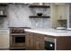 Modern kitchen with a Wolf oven and floating shelves at 9611 E Clinton St, Scottsdale, AZ 85260