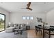 Open concept with a ceiling fan, featuring a comfortable sectional sofa, modern décor, and an adjacent dining area at 9611 E Clinton St, Scottsdale, AZ 85260