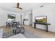 Open-concept living room with hardwood floors, a dining table, and modern entertainment center at 9611 E Clinton St, Scottsdale, AZ 85260