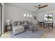 Bright living room featuring a comfortable sofa, modern lighting, a ceiling fan, and an adjacent dining area at 9611 E Clinton St, Scottsdale, AZ 85260