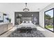 Elegant main bedroom with tufted headboard, decorative chandelier, and large windows offering lots of natural light at 9611 E Clinton St, Scottsdale, AZ 85260