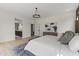 Bright main bedroom with a king bed, wood floors, and a modern gray and white aesthetic at 9611 E Clinton St, Scottsdale, AZ 85260