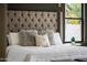 Close-up of a luxurious king bed in the main bedroom with accent pillows and a tufted headboard at 9611 E Clinton St, Scottsdale, AZ 85260