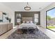 Beautiful main bedroom featuring a king bed, a modern chandelier, and backyard views from sliding glass doors at 9611 E Clinton St, Scottsdale, AZ 85260