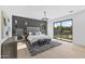 Spacious main bedroom features a plush bed, modern lighting, and sliding glass doors opening to the backyard at 9611 E Clinton St, Scottsdale, AZ 85260