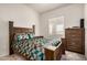 This bedroom features a patterned bed set, a large window, and wooden drawers at 10136 E Southern Ave # 3091, Mesa, AZ 85209