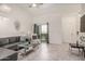 Bright living room with tile floors, sliding glass doors to the patio, and a modern gray leather couch at 10136 E Southern Ave # 3091, Mesa, AZ 85209