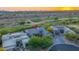Beautiful aerial view of a luxury home near a golf course with mountain views at sunset at 10179 E Camelot Ct, Scottsdale, AZ 85255