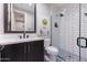 Modern bathroom featuring a walk-in shower, framed mirror, floating toilet, and unique floor tile at 10179 E Camelot Ct, Scottsdale, AZ 85255