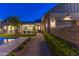 Exterior of a modern home at dusk with a pool, patio, and manicured lawn at 10179 E Camelot Ct, Scottsdale, AZ 85255