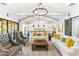 Open-concept living room featuring white sofas, vaulted ceilings, and a view into the kitchen with pendant lighting at 10179 E Camelot Ct, Scottsdale, AZ 85255