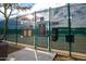 Close up of a tennis court entrance surrounded by a chain link fence at 10179 E Camelot Ct, Scottsdale, AZ 85255