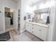 Well-lit bathroom with dual sinks, walk-in closet, and tiled shower at 10849 S 175Th Dr, Goodyear, AZ 85338