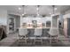 Stylish kitchen island features modern bar stools, pendant lighting, white cabinets, and stainless steel appliances at 10849 S 175Th Dr, Goodyear, AZ 85338