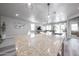 Spacious kitchen island with granite countertop and dining space, adjacent to an open living area at 10849 S 175Th Dr, Goodyear, AZ 85338