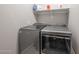 New laundry machines with gray finish, featuring gray walls and white shelving above at 10849 S 175Th Dr, Goodyear, AZ 85338