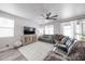 Spacious living room includes a large TV, modern decor, wood-look flooring, and neutral color palette at 10849 S 175Th Dr, Goodyear, AZ 85338