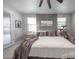 Beautifully staged main bedroom featuring a ceiling fan, gray accent wall, and ample natural light at 10849 S 175Th Dr, Goodyear, AZ 85338