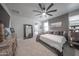 Well lit main bedroom with a ceiling fan, dresser, and decorative mirror at 10849 S 175Th Dr, Goodyear, AZ 85338