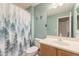 This bathroom features a large mirror, a single sink vanity, and a shower with a decorative curtain at 11003 E Ravenna Cir, Mesa, AZ 85212