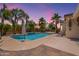 Inviting backyard pool with lush landscaping, swaying palm trees, and string lights at 11003 E Ravenna Cir, Mesa, AZ 85212