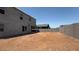 Large backyard featuring the house's rear elevation with a covered patio and block wall, ready for landscaping at 11444 E Utopia Ave, Mesa, AZ 85212