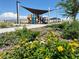 Community playground with sun shade, benches, and colorful flowers at 11444 E Utopia Ave, Mesa, AZ 85212