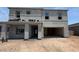 Unfinished two-story home with covered entry, a two-car garage, and visible construction materials at 11444 E Utopia Ave, Mesa, AZ 85212