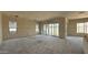 A large living area under construction shows drywall walls, sliding glass doors, and concrete floors at 11444 E Utopia Ave, Mesa, AZ 85212