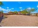 Large backyard features gravel, block wall, and desert landscaping under a bright sky at 12709 N El Frio St, El Mirage, AZ 85335