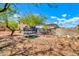 Messy backyard featuring a trampoline, cinderblock wall, and desert landscaping under a blue sky at 12709 N El Frio St, El Mirage, AZ 85335